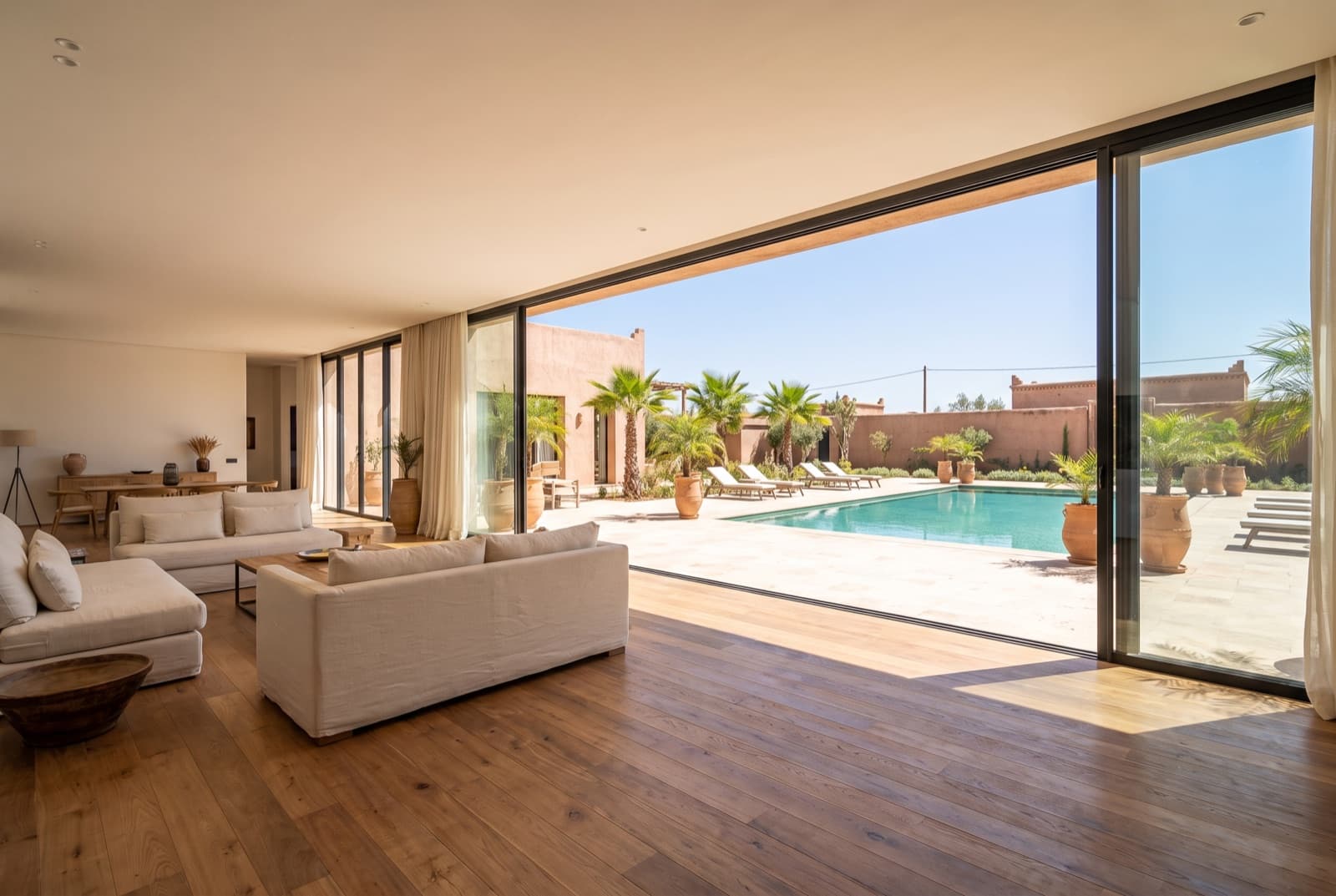 Baies vitrées toute hauteur en aluminium fin, ouvertes sur la piscine